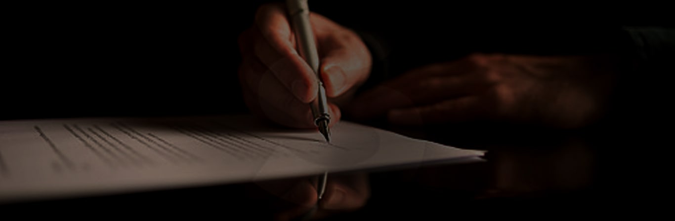 man with pen writing on paper